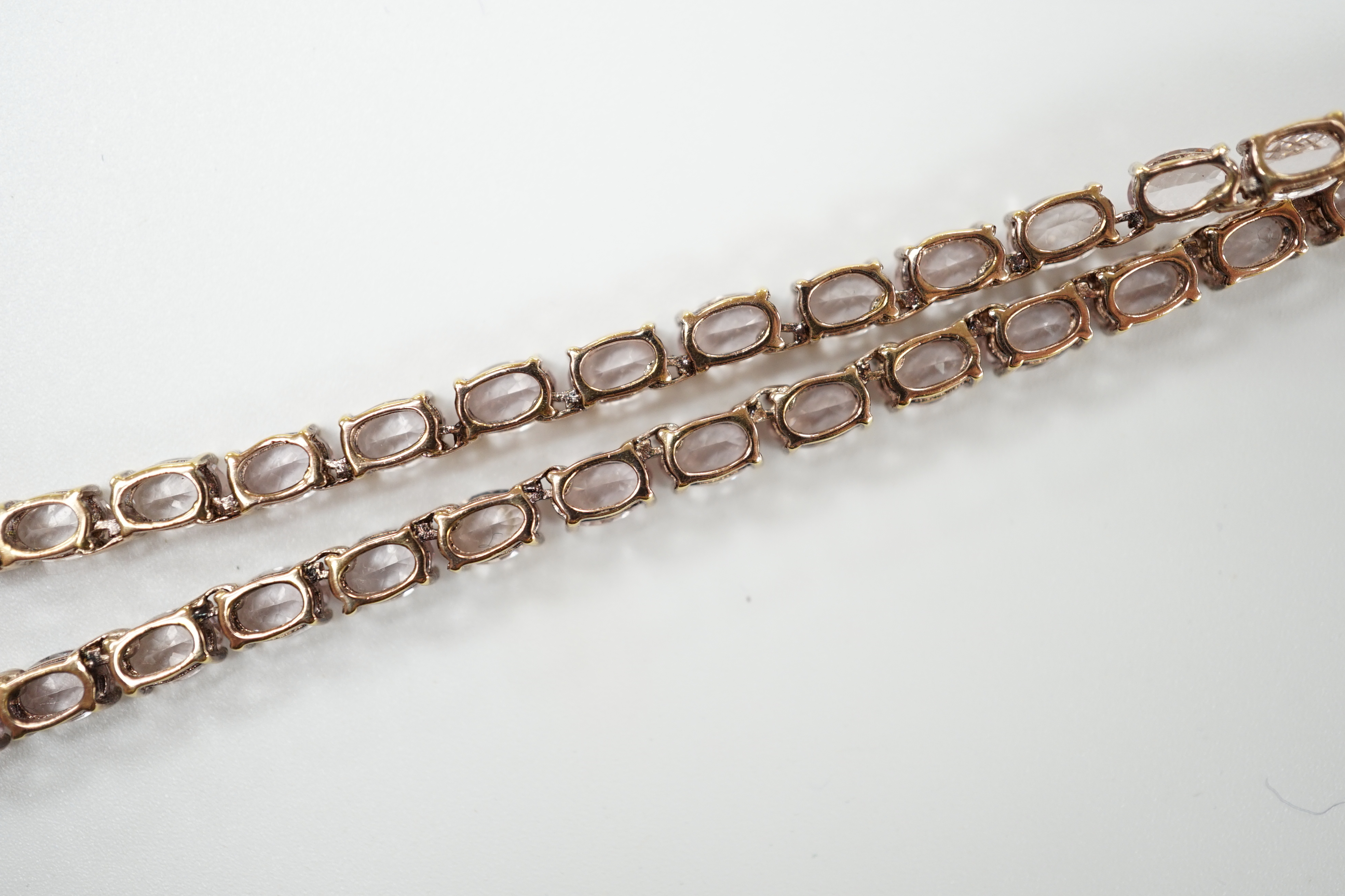 A modern 925 gilt metal and oval cut morganite set line necklace, 46cm.
